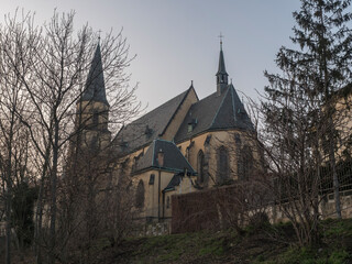 View of gothic church of saint Apolinar in czech Kostel sv. Apolinare with bare trees at old Prague center