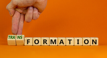 Formation or transformation symbol. Businessman turns cubes and changes the word formation to transformation. Beautiful orange background. Business, formation or transformation concept. Copy space.