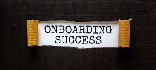 Onboarding success symbol. Words 'Onboarding success' appearing behind torn black paper. Beautiful black background. Business, onboarding success concept, copy space.