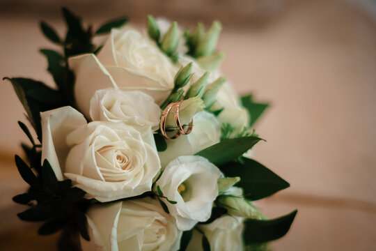 Close-up image of the bride's bouquet and wedding rings on it with blur.