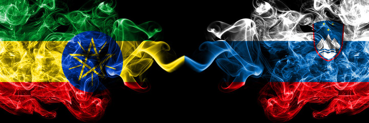 Ethiopia, Ethiopian vs Slovenia, Slovenian smoky mystic flags placed side by side. Thick colored silky abstract smoke flags.