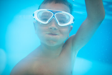 Naklejka premium Cute little boy in a swimming pool