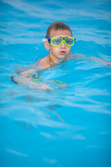 Naklejka premium Cute little boy in a swimming pool