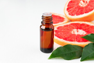 Close-up citrus oil with red grapefruit and leaves. Spa, aromatherapy and massage with essential oils.