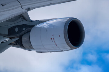 A closeup of a turbojet engine of a modern airplane against cloudy sky