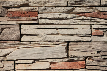 Decorative wall texture, background. Stone cladding in different colors grungy and matted stone bricks. The fragment of a new decorative stone laying. The design of multi-colored stylish exterior