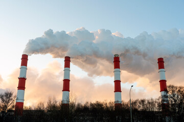 Air pollution by harmful emissions. Pipes with smoke on the background of a blue sk
