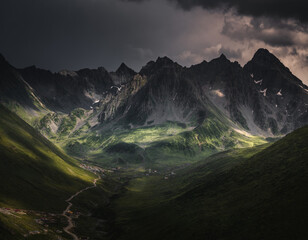 An epic mountain range at the end of a deep valley and a dramatic sky with full of dark clouds....