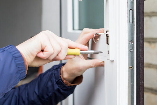 Handyman installing door lock in front door.