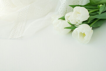 Fototapeta na wymiar bouquet of white tulips on white silk background