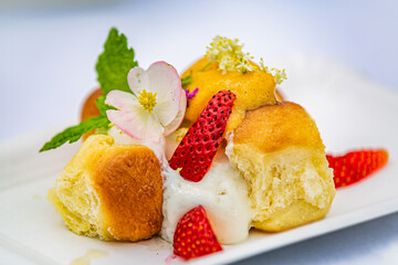 Baked buns with cream and strawberries. Food styling for street food. Closeup.