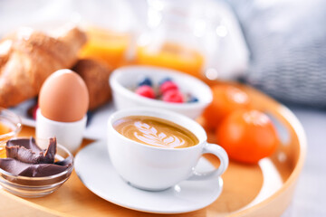 A tray with breakfast on a bed in a hotel room