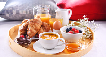 A tray with breakfast on a bed in a hotel room