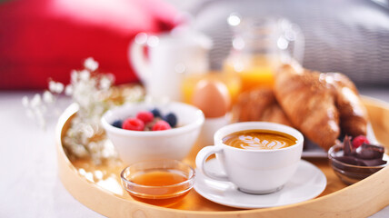 A tray with breakfast on a bed in a hotel room
