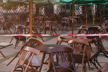 Open-air cafe in vintage style - closed. Red and white lines of barrier tape, protects for no entry (concept: emergency, quarantine)