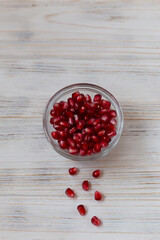 Pomegranate seeds in a bowl on a light background