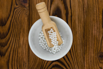 Homeopathy alternative medicine eco concept - classical homeopathy pills. Homeopathic globules on wooden background. 