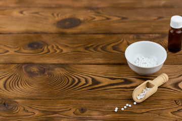 Homeopathy alternative medicine eco concept - classical homeopathy pills. Homeopathic globules on wooden background. 