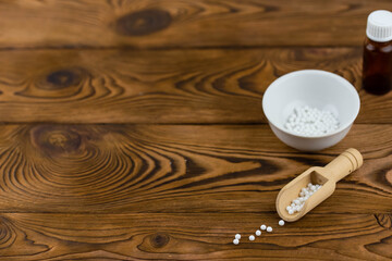 Homeopathy alternative medicine eco concept - classical homeopathy pills. Homeopathic globules on wooden background. 