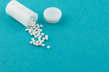 Homeopathy alternative medicine eco concept - classical homeopathy pills. Homeopathic globules on blue background. 