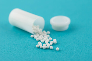 Homeopathy alternative medicine eco concept - classical homeopathy pills. Homeopathic globules on blue background. 