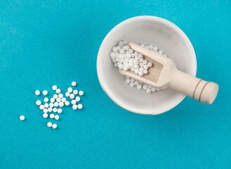Homeopathy alternative medicine eco concept - classical homeopathy pills. Homeopathic globules on blue background. 