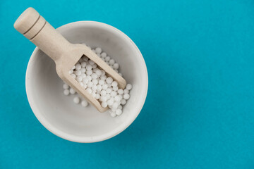 Homeopathy alternative medicine eco concept - classical homeopathy pills. Homeopathic globules on blue background. 