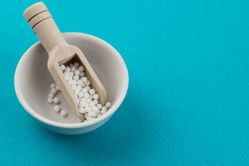 Homeopathy alternative medicine eco concept - classical homeopathy pills. Homeopathic globules on blue background. 