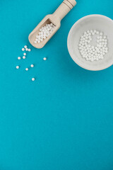 Homeopathy alternative medicine eco concept - classical homeopathy pills. Homeopathic globules on blue background. 