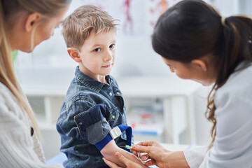 Little boy having blood sample drawn in a lab
