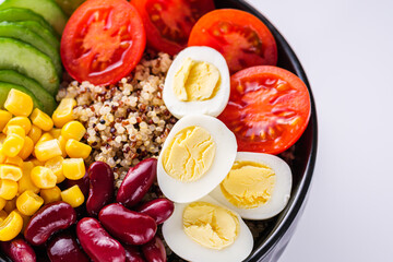 bowl of healthy quinoa with vegetables on a white background