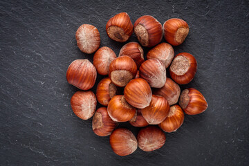 fresh natural hazelnuts on a dark stone background