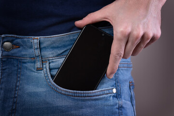 Smartphone in hand in a pocket in jeans