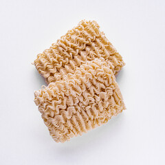 instant egg noodles on a white acrylic background