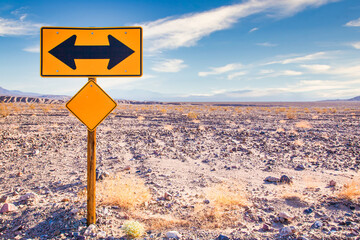 Directional sign in the desert with scenic blue sky and wide horizon. Concept for trip, freedom and transportation.