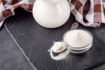 granulated milk powder on a dark stone background