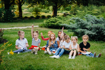 Fototapeta premium A teacher teaches a class of children in an outdoor Park. Back to school, learning during the pandemic