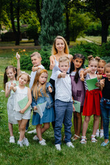A teacher teaches a class of children in an outdoor Park. Back to school, learning during the pandemic