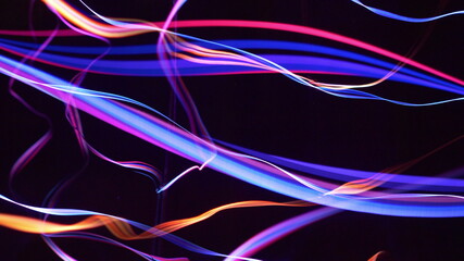 Colorful fiber strings in motion against black background