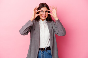 Young caucasian business woman isolated on pink background keeping eyes opened to find a success opportunity.