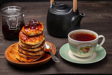 breakfast with tea and cheesecakes poured with gooseberry jam