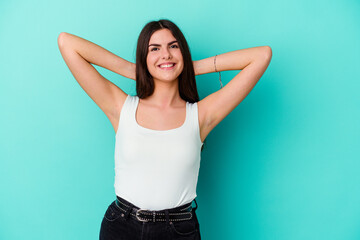 Young caucasian woman isolated on blue background stretching arms, relaxed position.