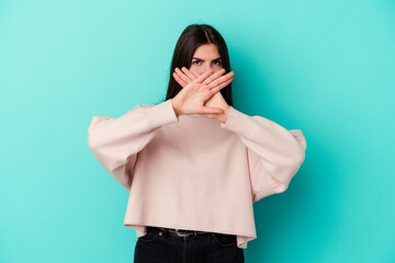 Young caucasian woman isolated on blue background doing a denial gesture