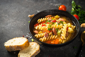 Vegetable soup with pasta and sausages.