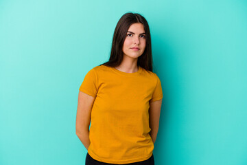 Young caucasian woman isolated on blue background sad, serious face, feeling miserable and displeased.