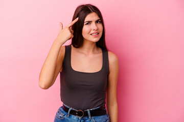 Young caucasian woman isolated on pink background showing a disappointment gesture with forefinger.