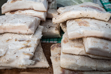 Chunks of salted lard with dill at the village market. Natural food.