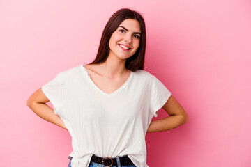 Young caucasian woman isolated on pink background confident keeping hands on hips.