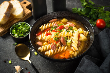 Vegetable soup with pasta and sausages.