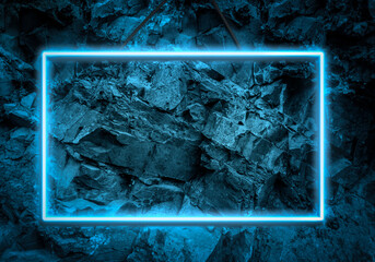 blue neon glowing frame on a background of a layer of stones